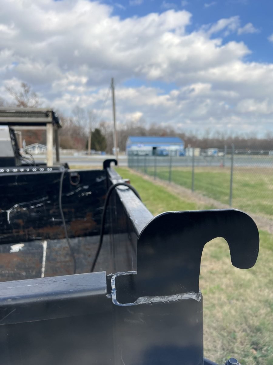 Weld-on hook bracket fabricated and welded onto a steel dump trailer body